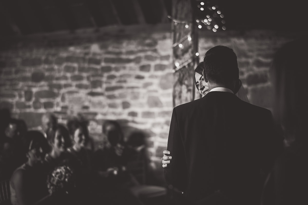 A wedding ceremony captured in a black and white photo, featuring the bride and groom.