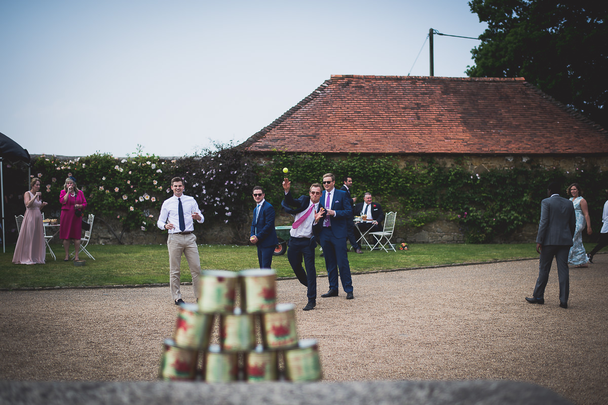 A group of people, including the bride and groom, playing a game of ping pong.