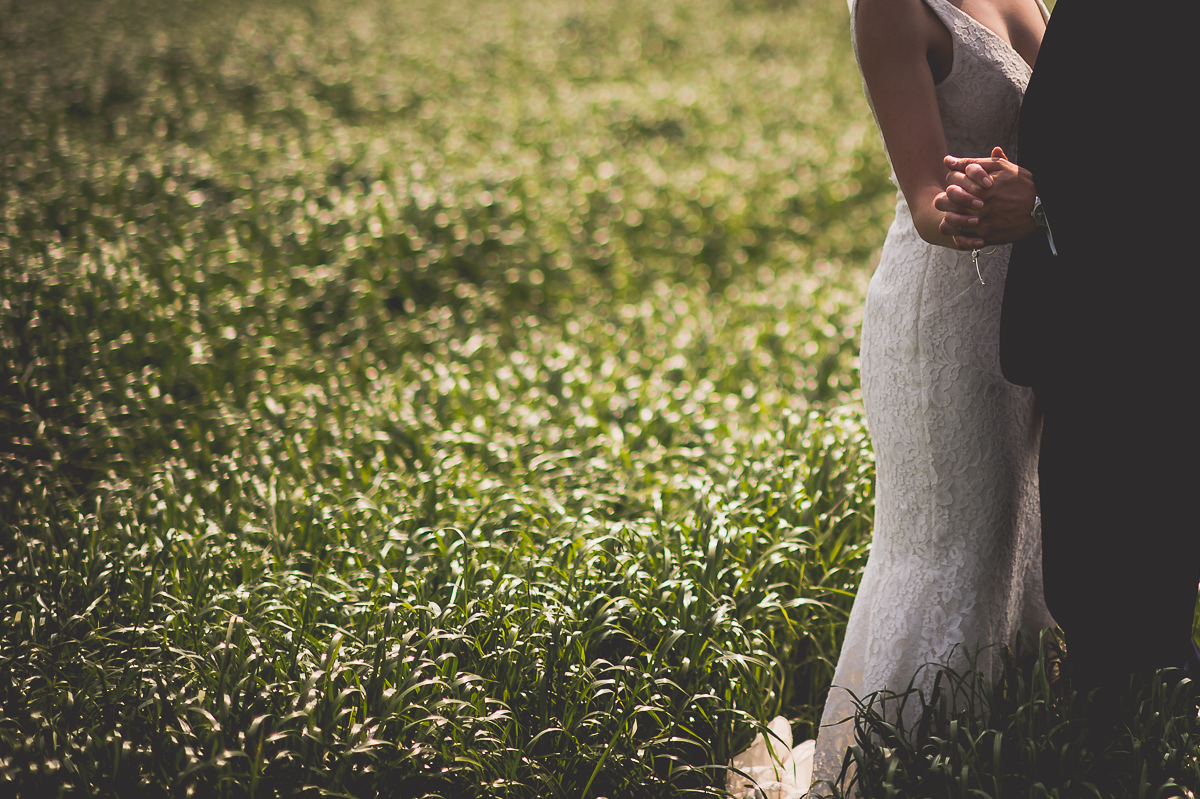 A wedding couple posing for photos in a field.