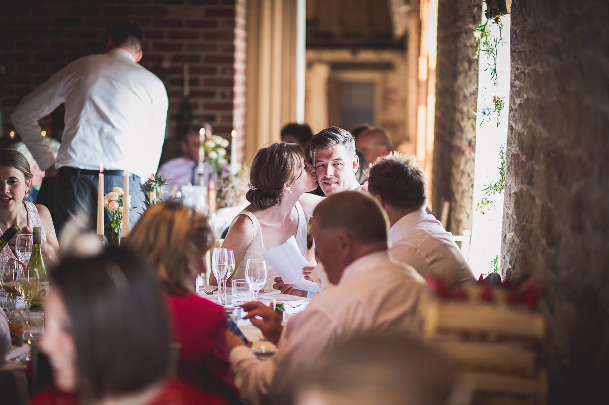 A bride and groom capturing a kiss in their wedding photos.