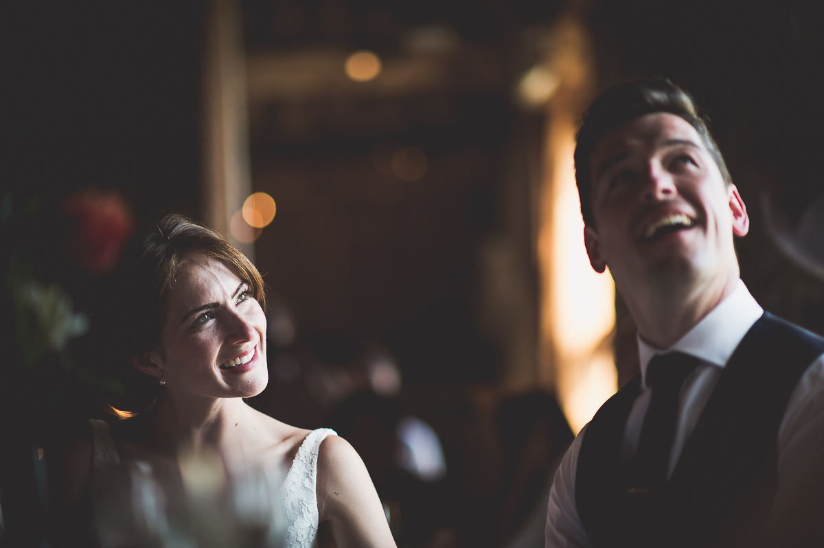 A bride and groom captured in joyful laughter at their wedding, immortalized in their wedding photos.