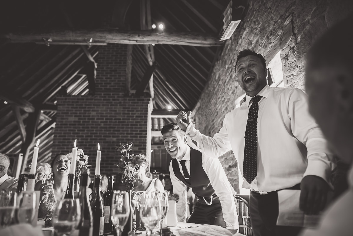 A monochrome image capturing the groom and wedding photographer at a wedding.