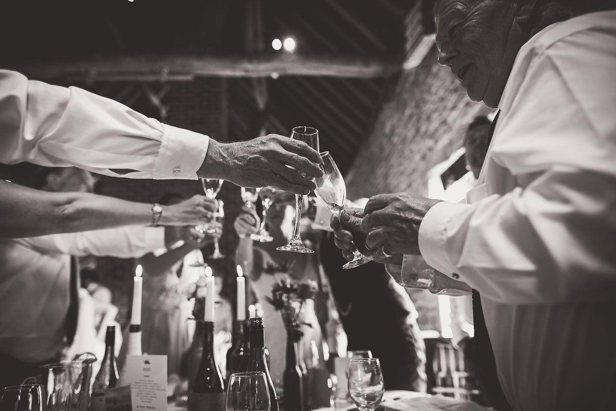 A black and white wedding photo of people toasting.