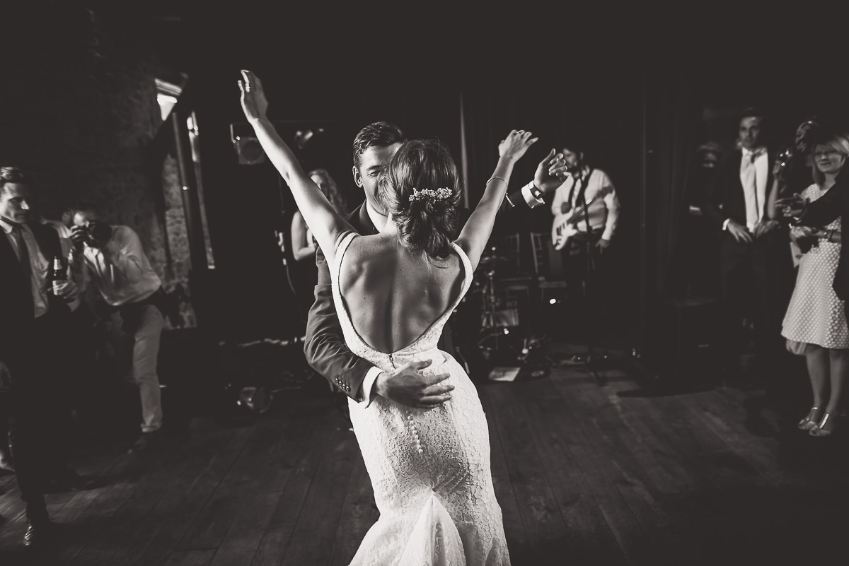 A black and white wedding photo of a bride and groom dancing.