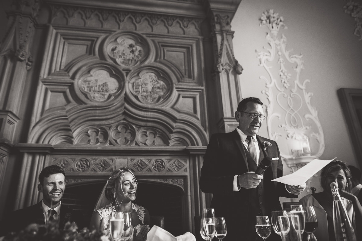 A wedding photo of a man giving a speech.