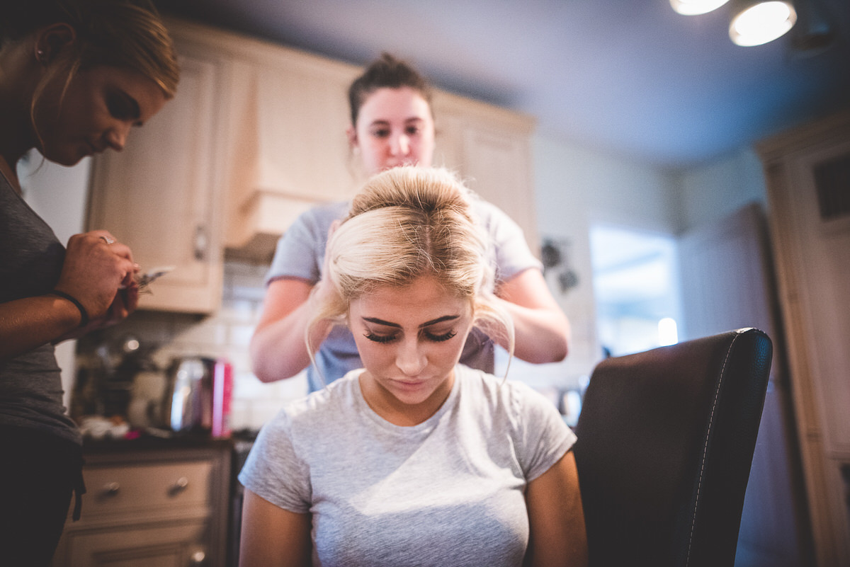 A bride being groomed by a wedding photographer for her wedding photo.