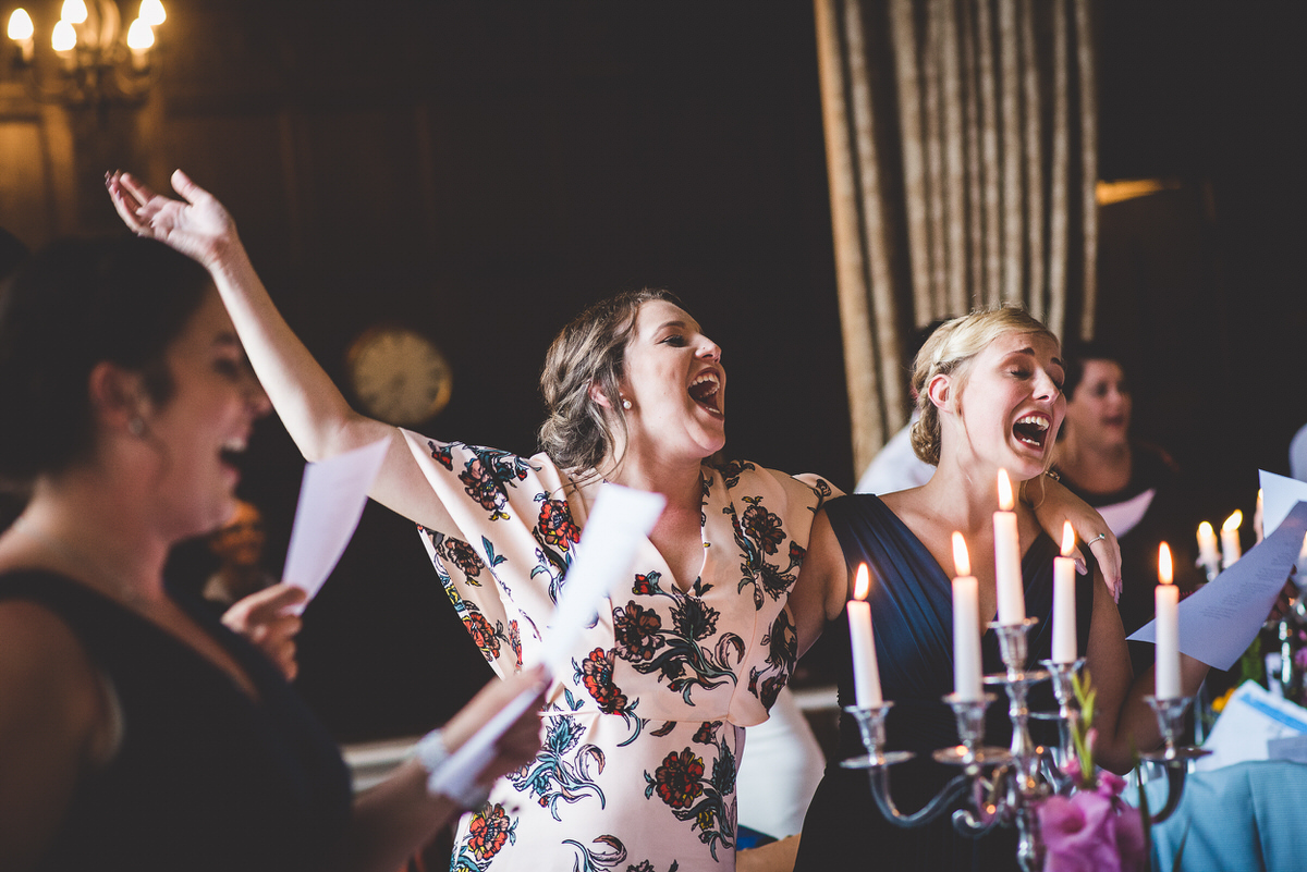 A group of bridesmaids serenading the bride and groom at their wedding reception.