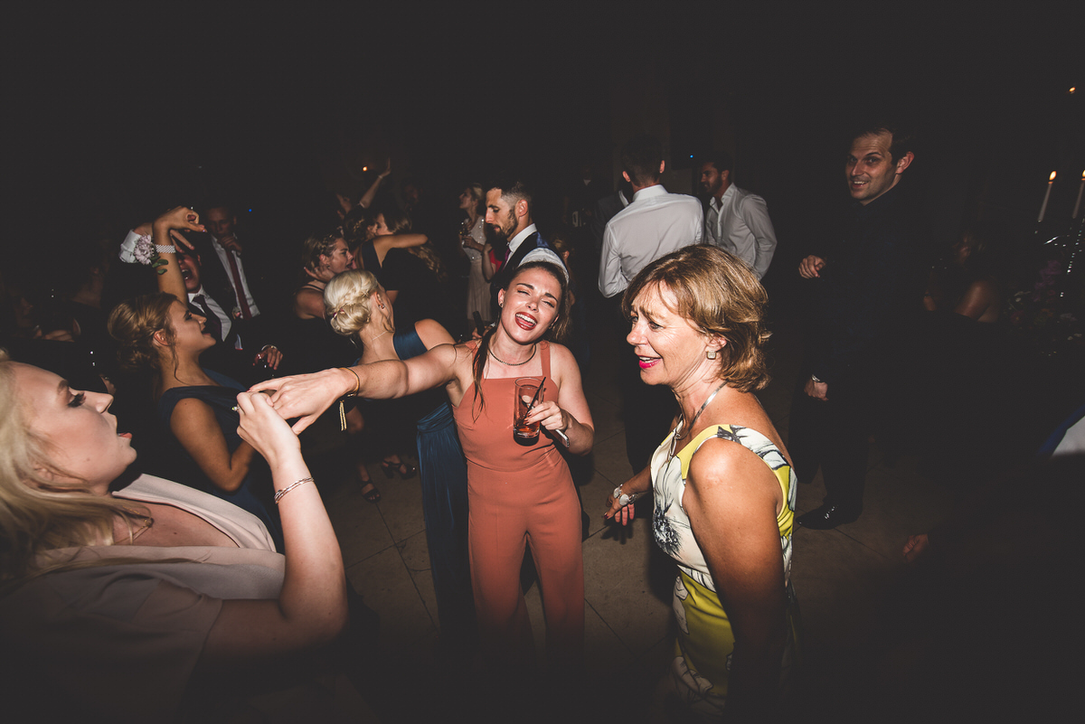 A group of people dancing at a wedding party captured by a wedding photographer.