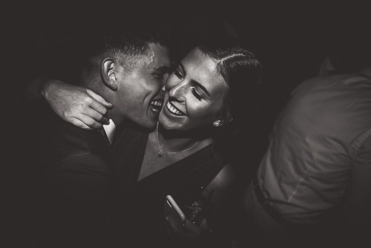 A black and white photo of a couple hugging at a wedding.