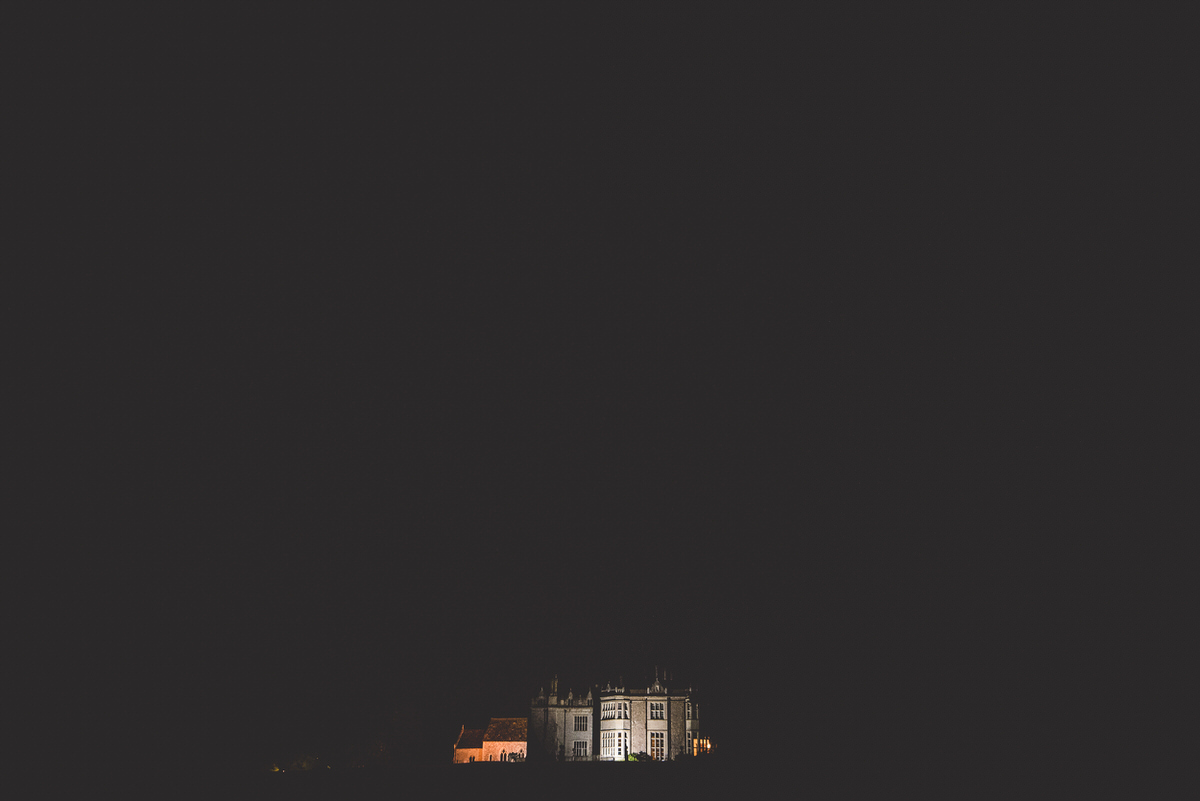 A castle illuminated at night in Ireland captures the romance of a wedding day for a bride and groom.