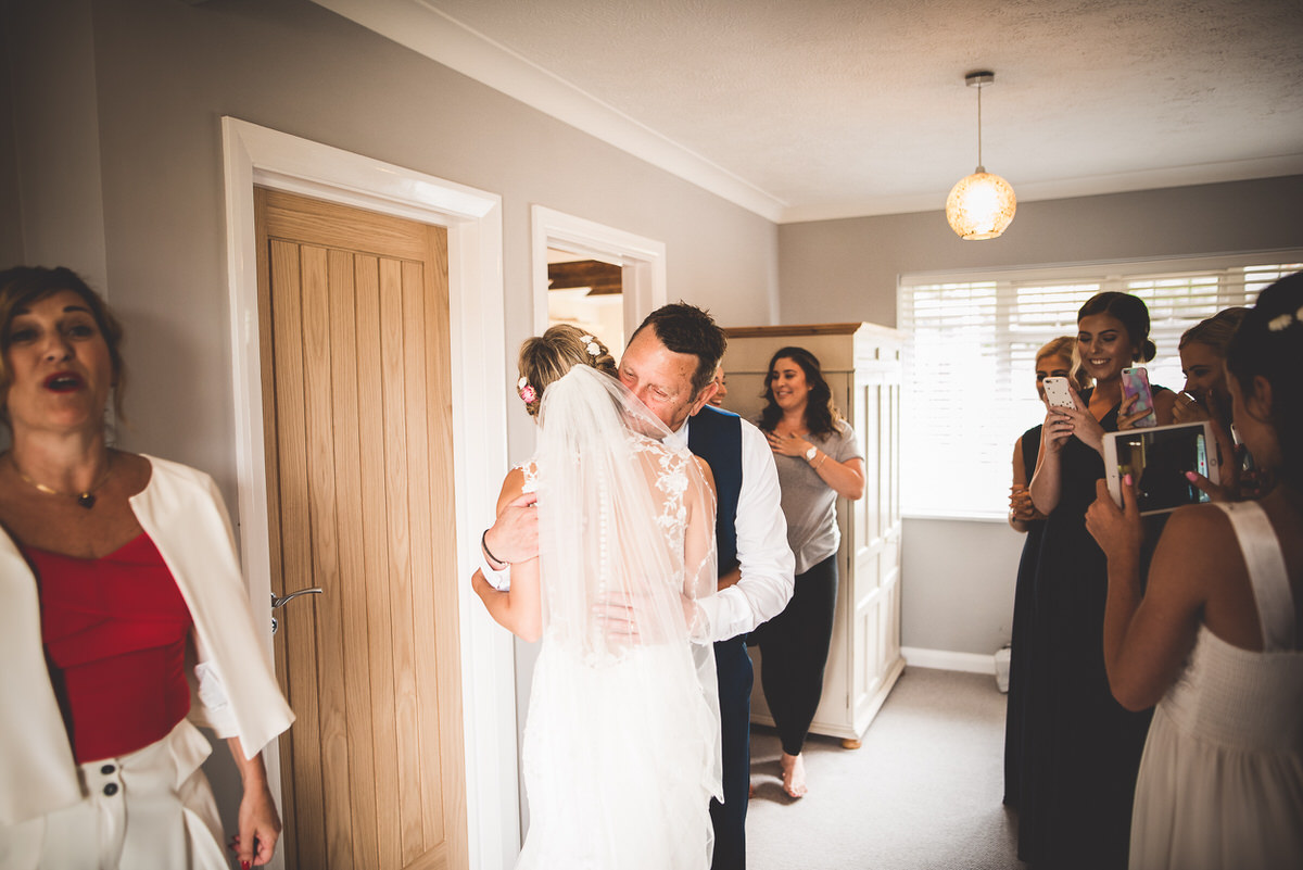 A bride and groom posing lovingly for a wedding photo in front of a mirror.