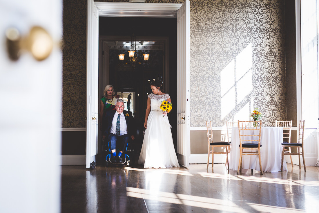 A wedding photographer capturing a bride in a wheelchair for a unique wedding photo.