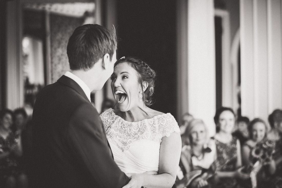 A wedding photographer captures the joyful bride and groom during their ceremony.