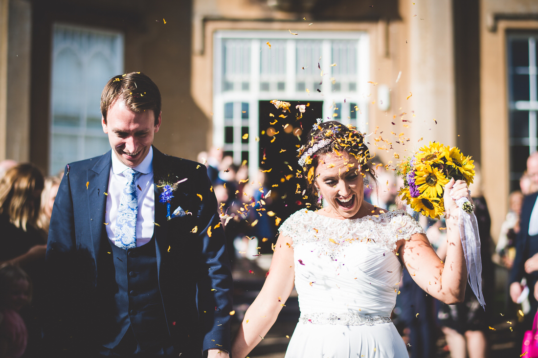 Bride and groom posing in wedding photo with confetti.