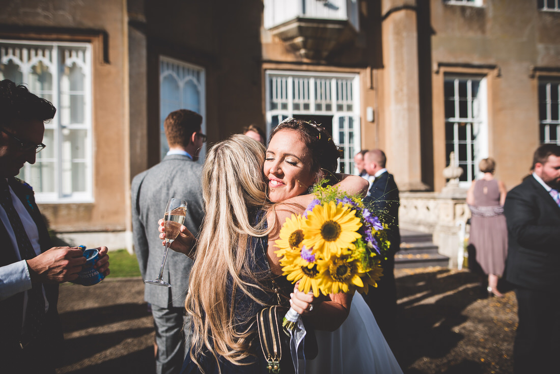 A wedding photo capturing the embrace between the bride and groom in front of a mansion.