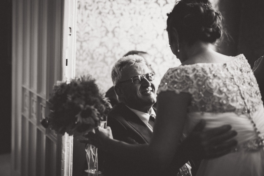 A black and white photo of a bride hugging her father on her wedding day, captured by a wedding photographer.