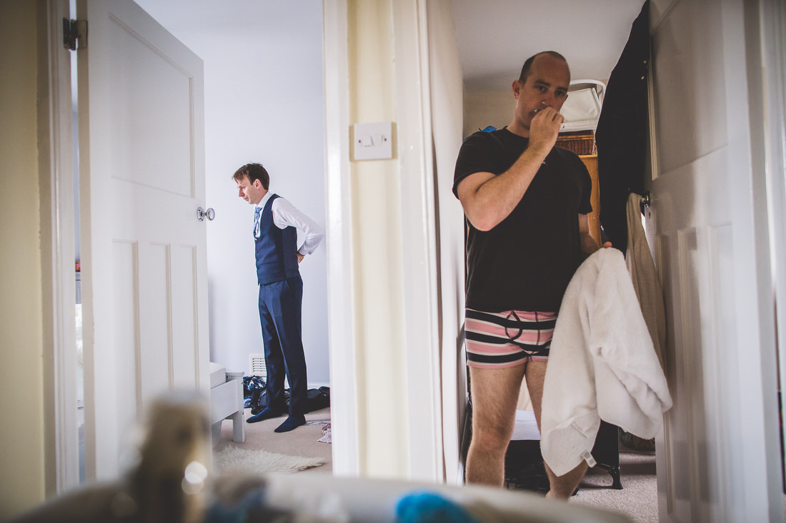 A man in a suit is examining his reflection in a wedding photo.