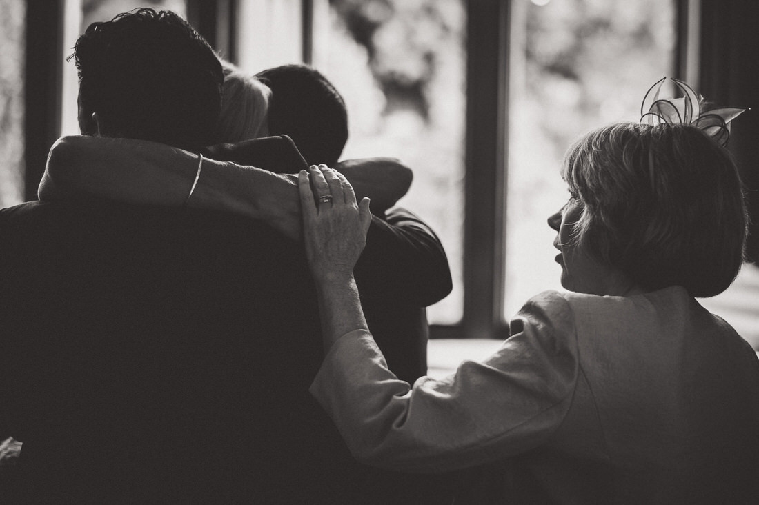 A wedding photo capturing people hugging each other in black and white.