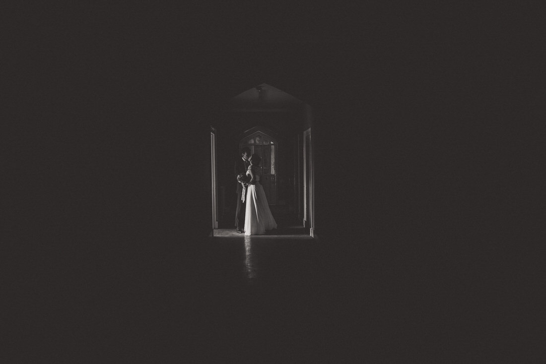A wedding photo capturing the bride and groom in a dark room.