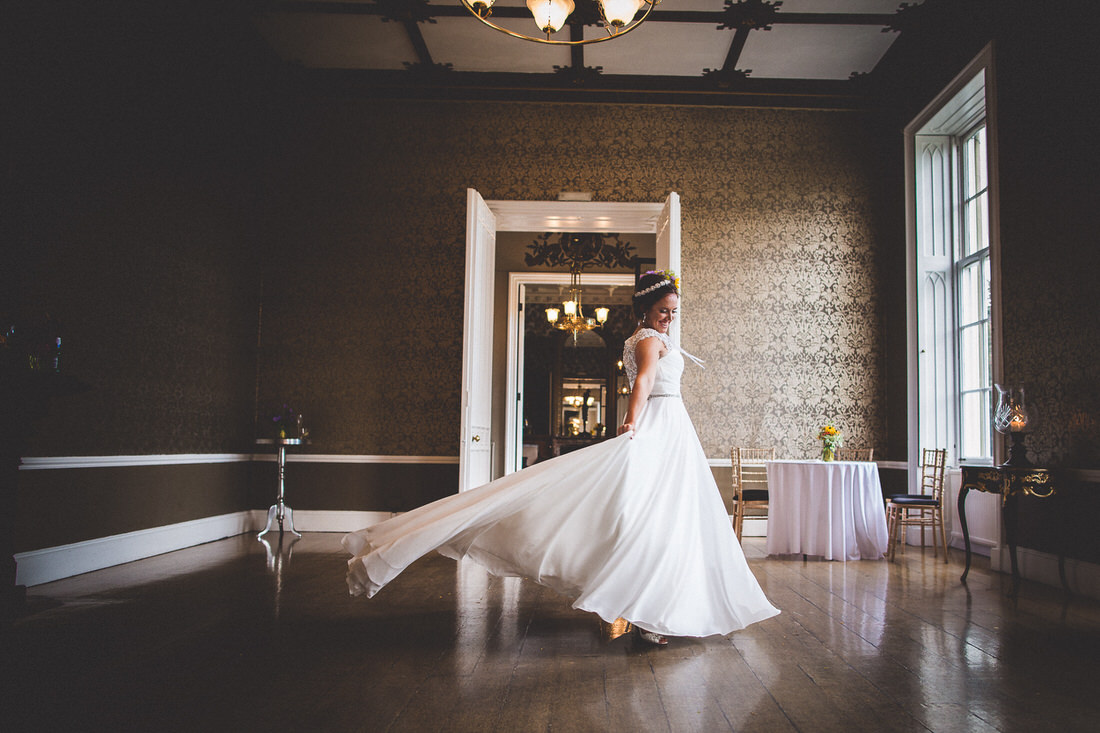 A wedding photographer captures a bride in her wedding dress during a photoshoot.