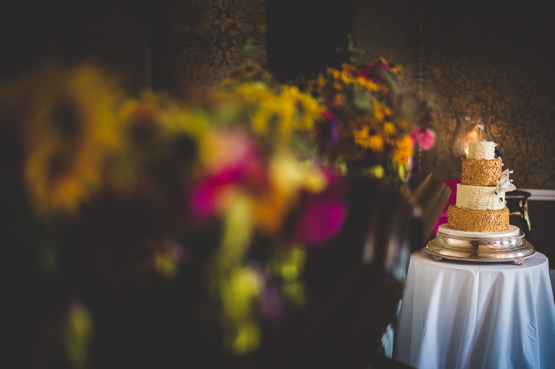 A wedding cake is captured in a stunning wedding photo, displayed on a table adorned with flowers.