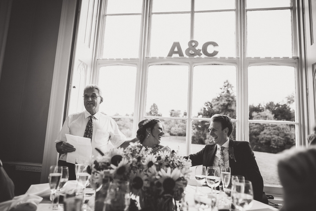 Black and white wedding photo of a man giving a speech.