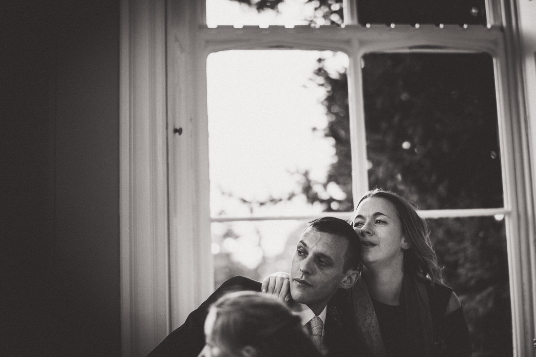 A black and white wedding photo of a couple in front of a window captured by a wedding photographer.