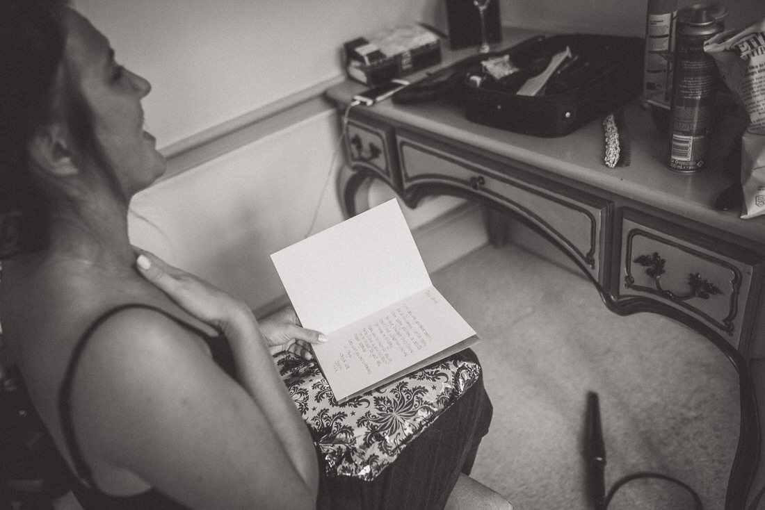 A bride reading a book in front of a mirror.