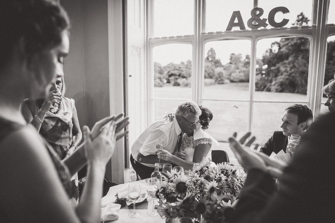 A wedding photo capturing the groom's applause during a reception.