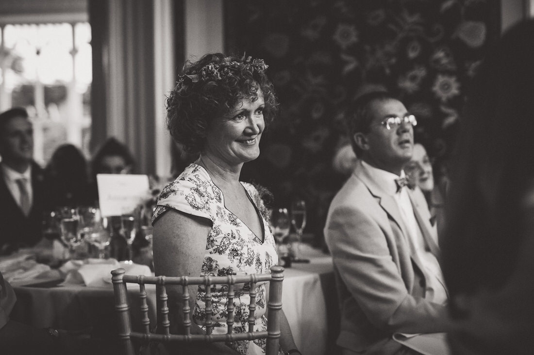 A black and white wedding photo of a bride sitting at a table.