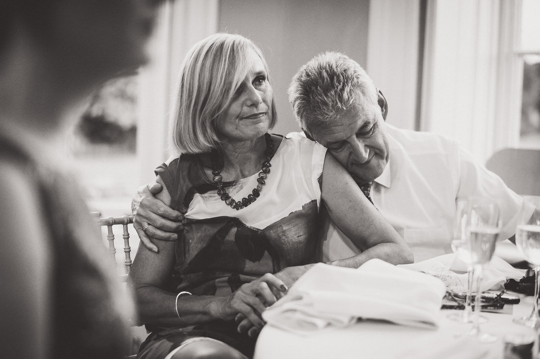 A groom and bride hugging at their wedding reception.