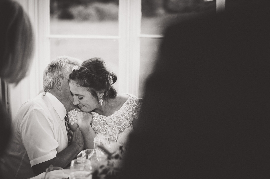 A bride and groom embracing in front of a window, captured by a wedding photographer.