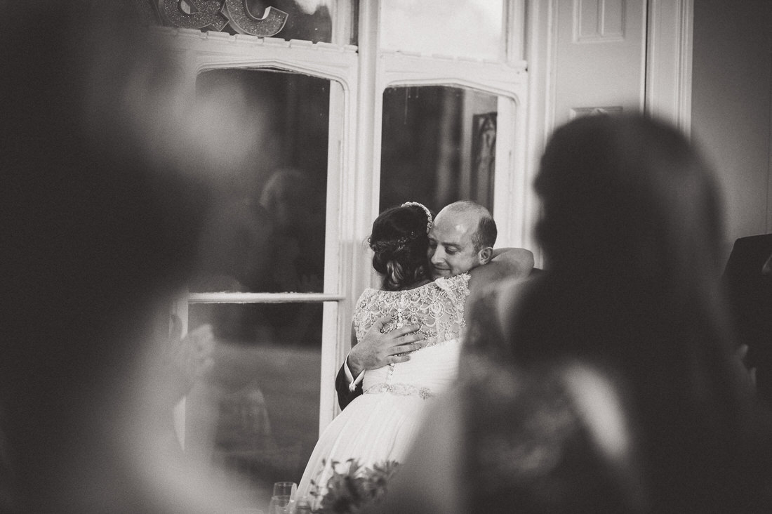 A wedding couple embracing in front of a mirror.