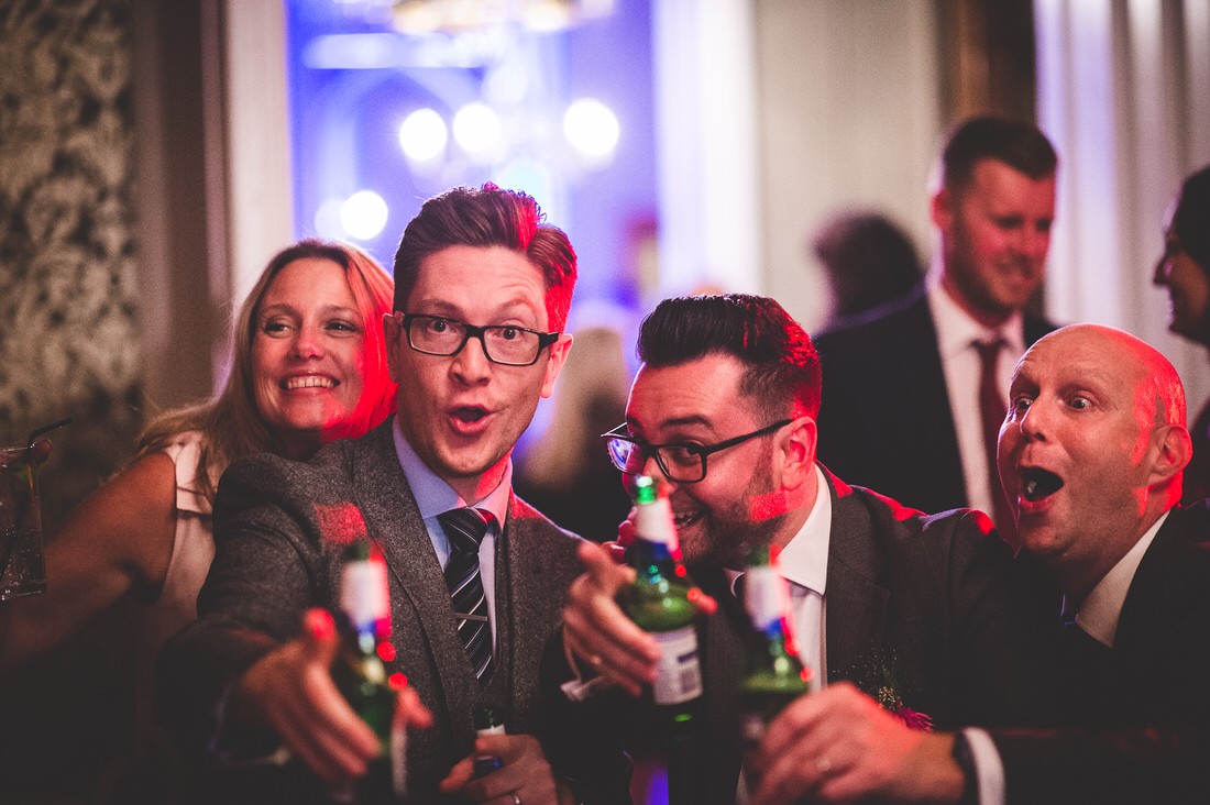 A group of wedding guests enjoying beer at a party.
