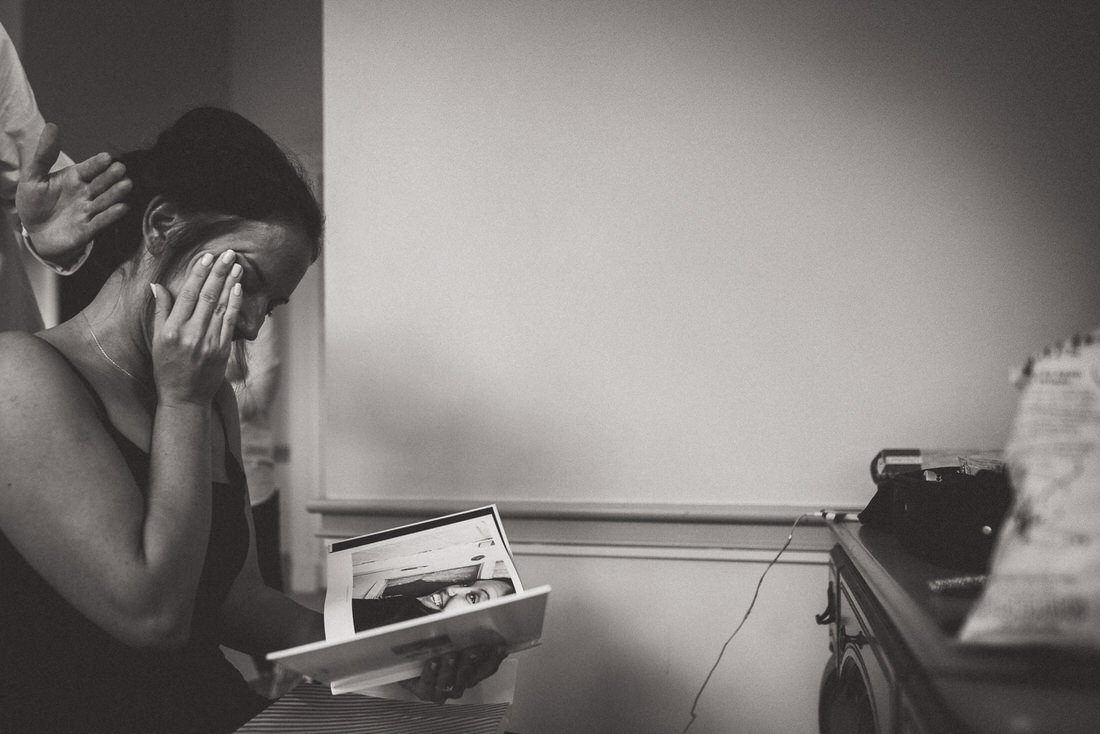 A woman is reading a book while getting ready for her wedding, reflected in a mirror.