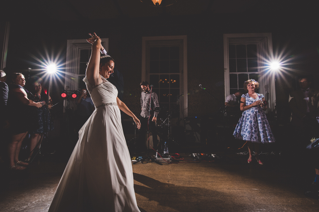 A wedding photographer captures the bride and groom dancing at a reception.