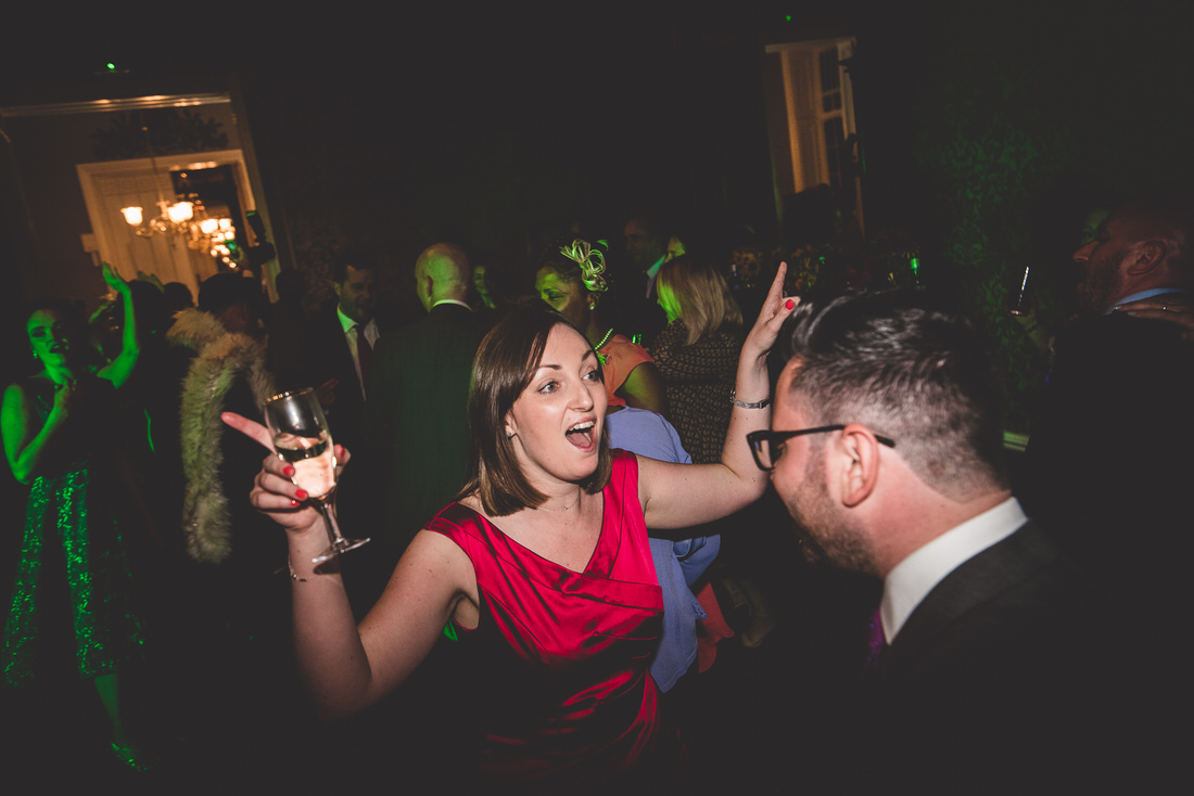 A groom and bride dancing at their wedding party, while a wedding photographer captures the moment.