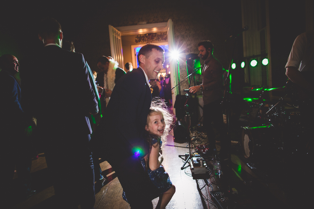 A man and a little girl dancing at a wedding.