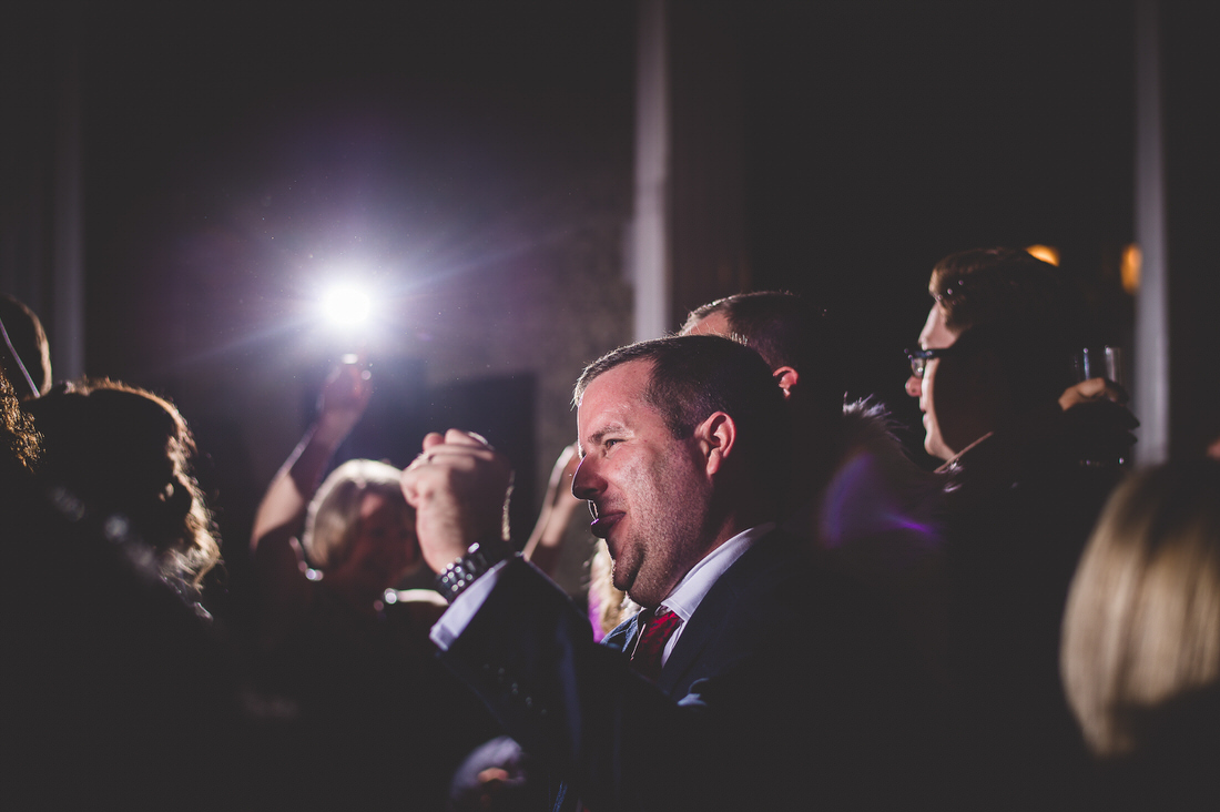 A man in a suit is holding a microphone during the wedding ceremony.