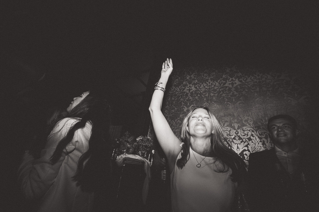 A wedding photo showcasing a jubilant woman raising her arms in celebration.