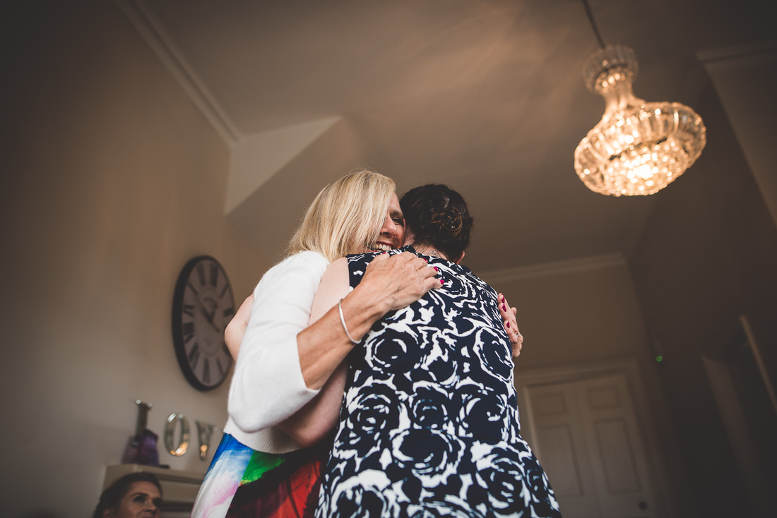 Two women hugging each other at a wedding.