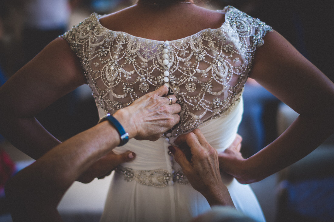 A bride is getting dressed for her wedding.