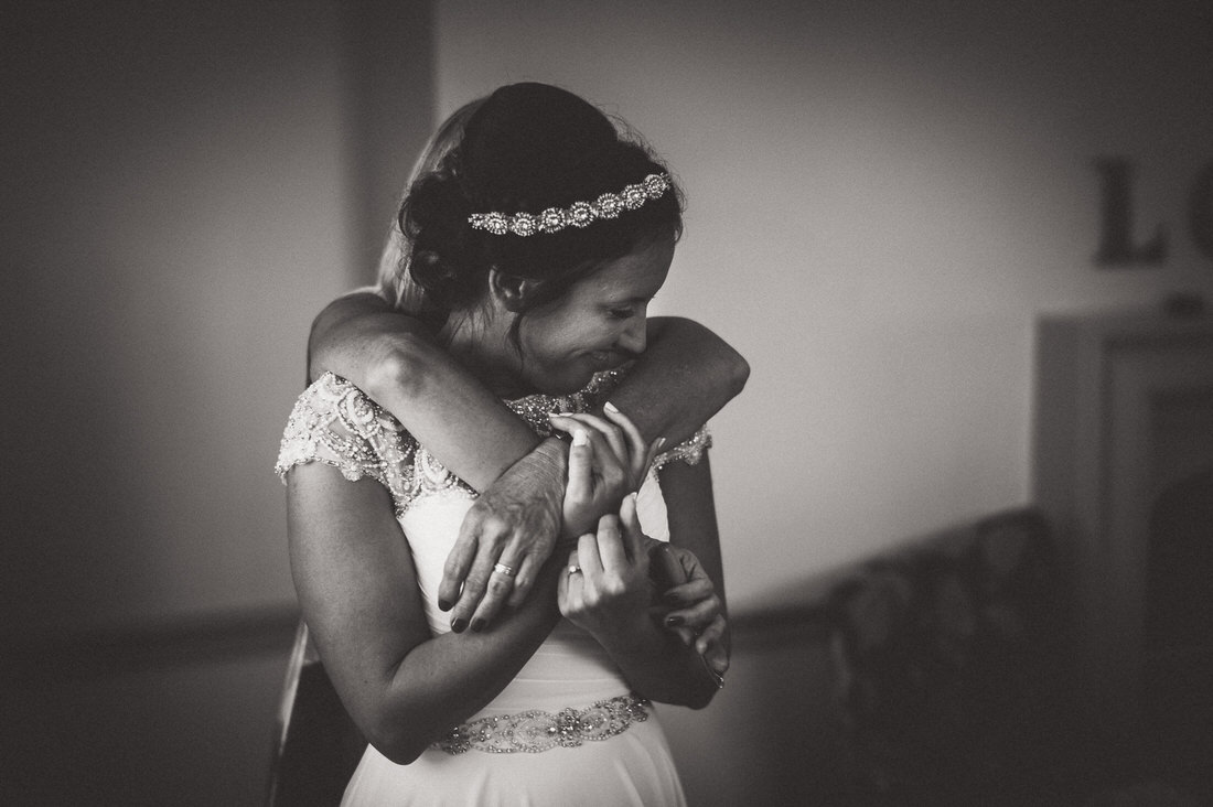 A bride hugging her mother at her wedding.