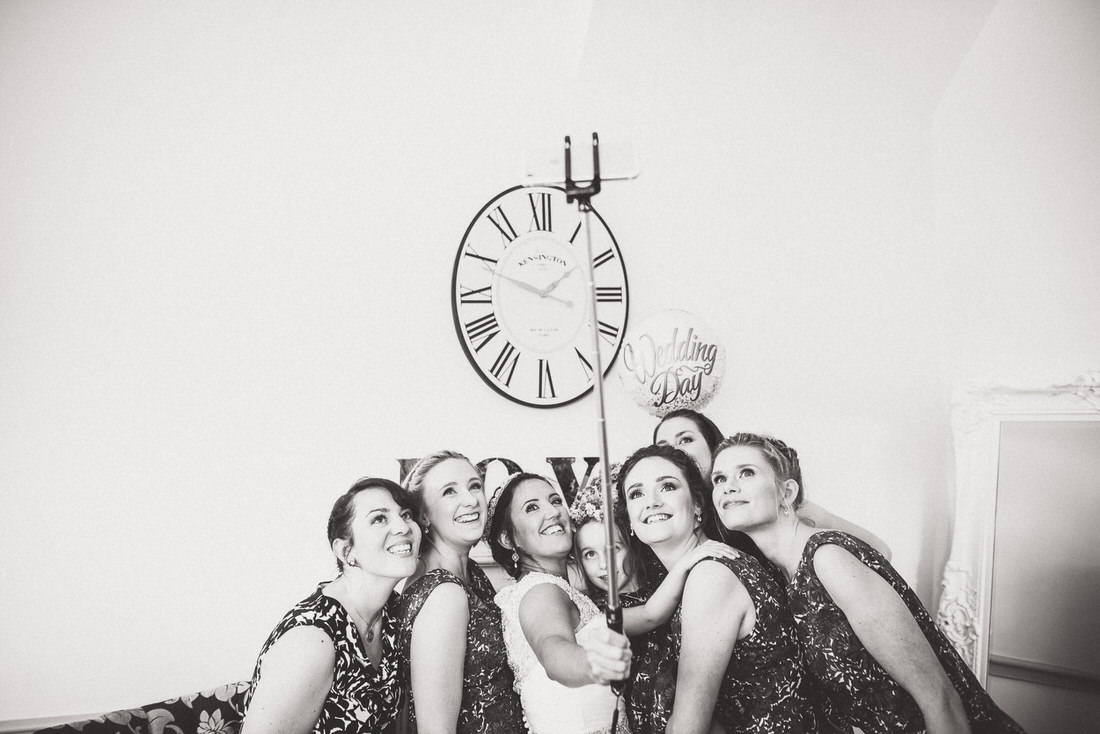 A group of bridesmaids posing in front of a wedding clock.