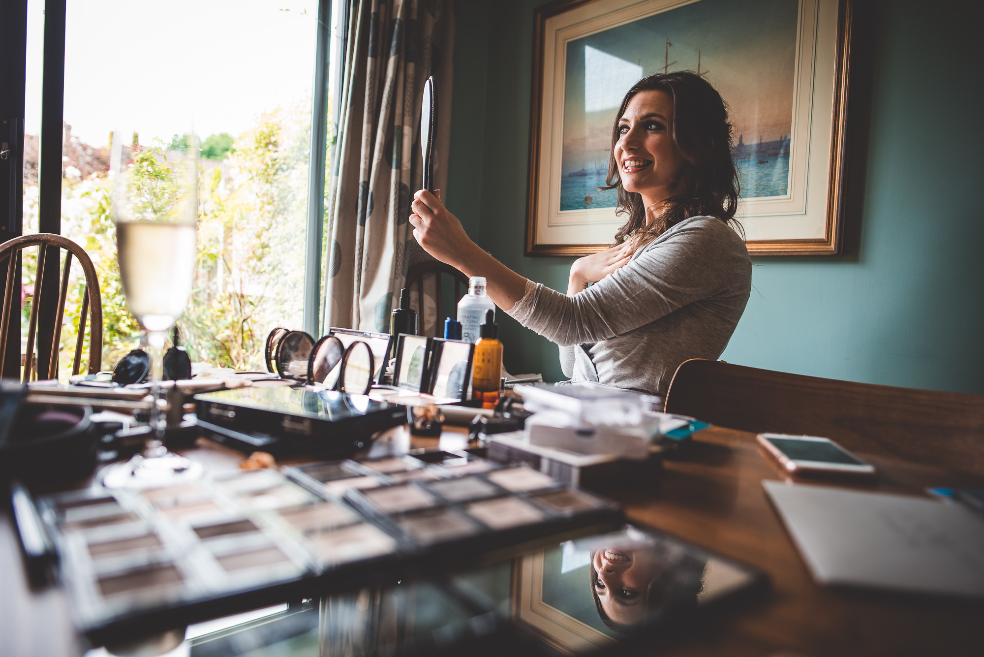 A bride at a table with makeup on her face in a wedding photo.