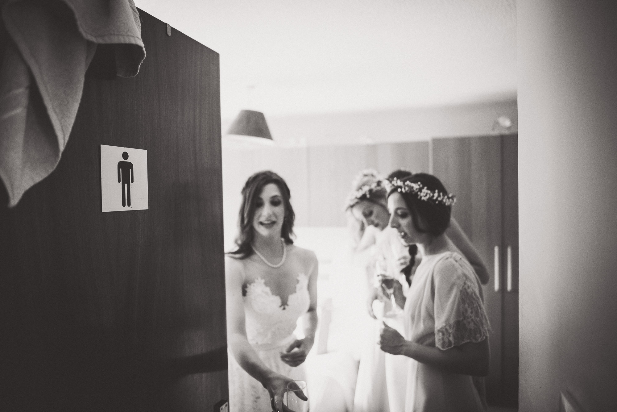 A bride and her bridesmaids are getting ready for a wedding, captured by a wedding photographer.