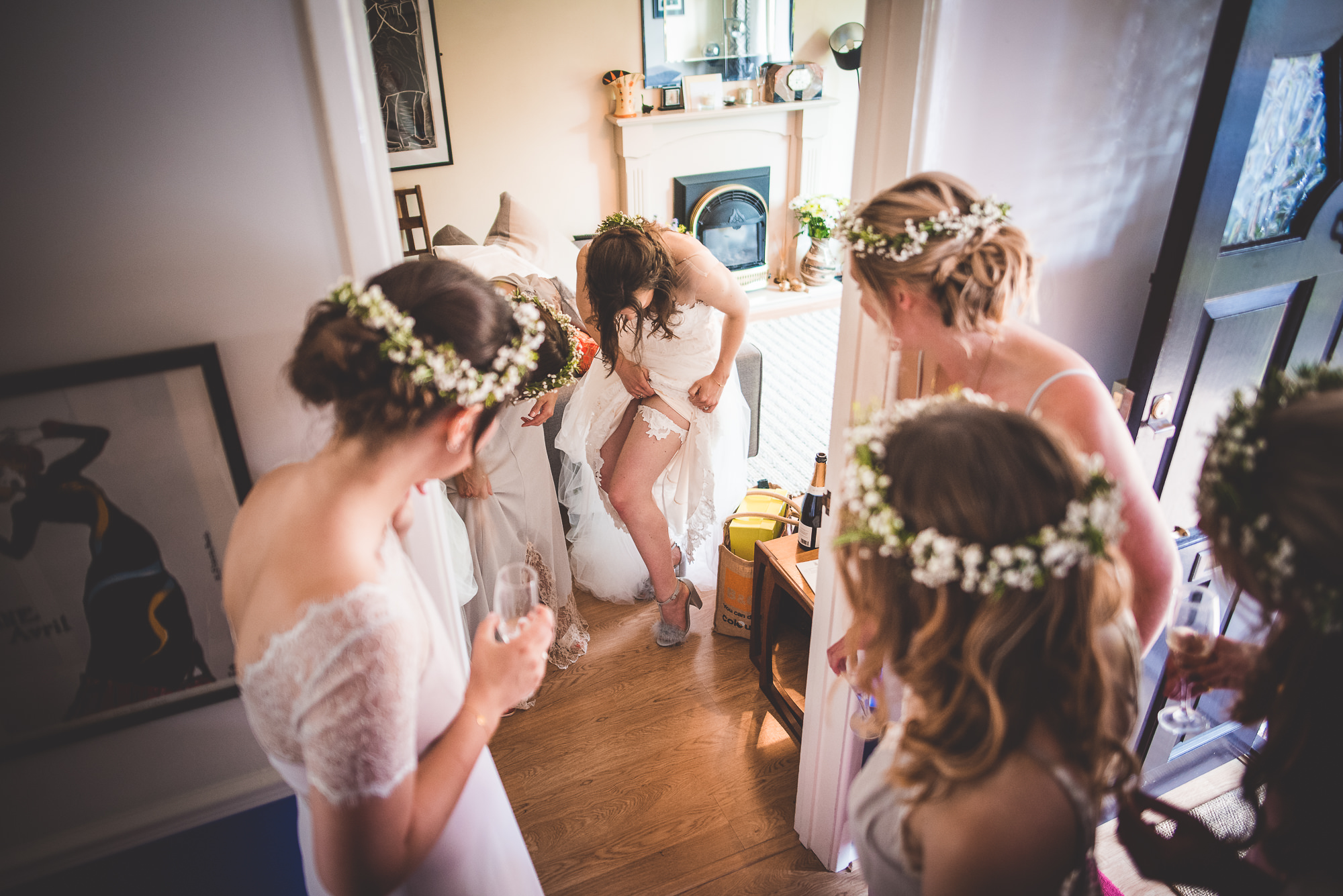 A group of bridesmaids preparing for a wedding in front of a mirror.