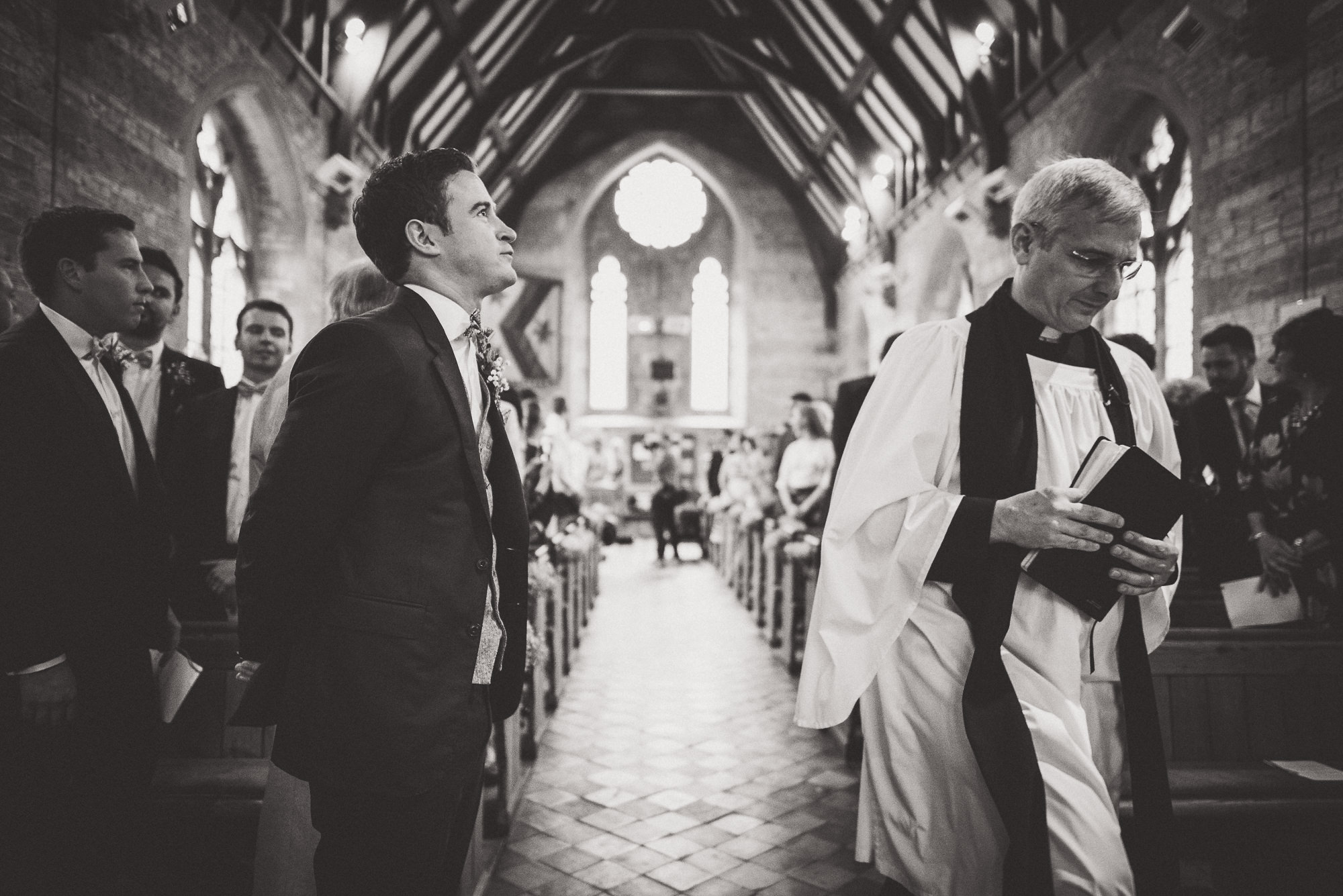 A groom walking down the aisle of a church during his wedding.