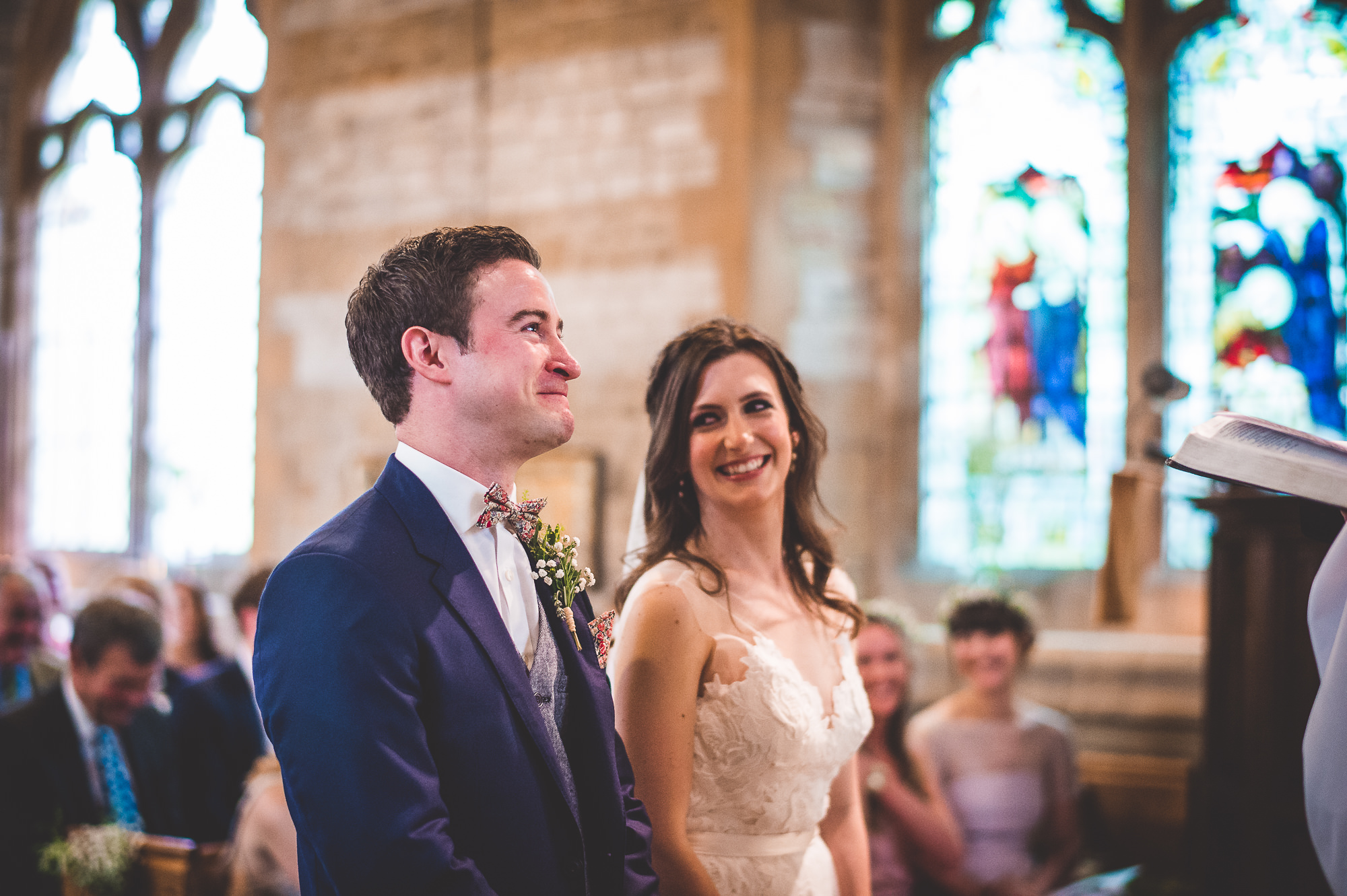 A wedding photographer captures a beautiful moment as the bride and groom exchange loving gazes during their wedding ceremony.