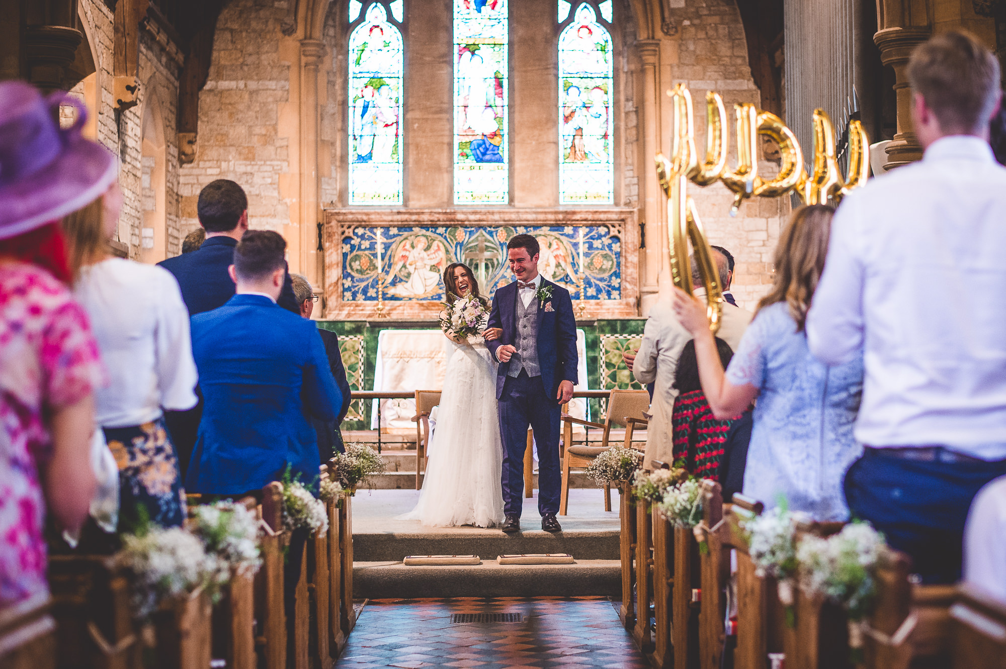 A wedding couple walking down the aisle in a church.